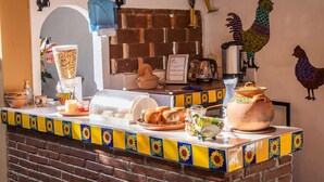 Una encimera de cocina con varios objetos, entre ellos una cafetera, un hervidor y una olla grande.