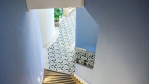 Una escalera conduce a un patio con losetas y diseños geométricos.