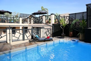 Piscine couverte, piscine extérieure, parasols de plage, chaises longues