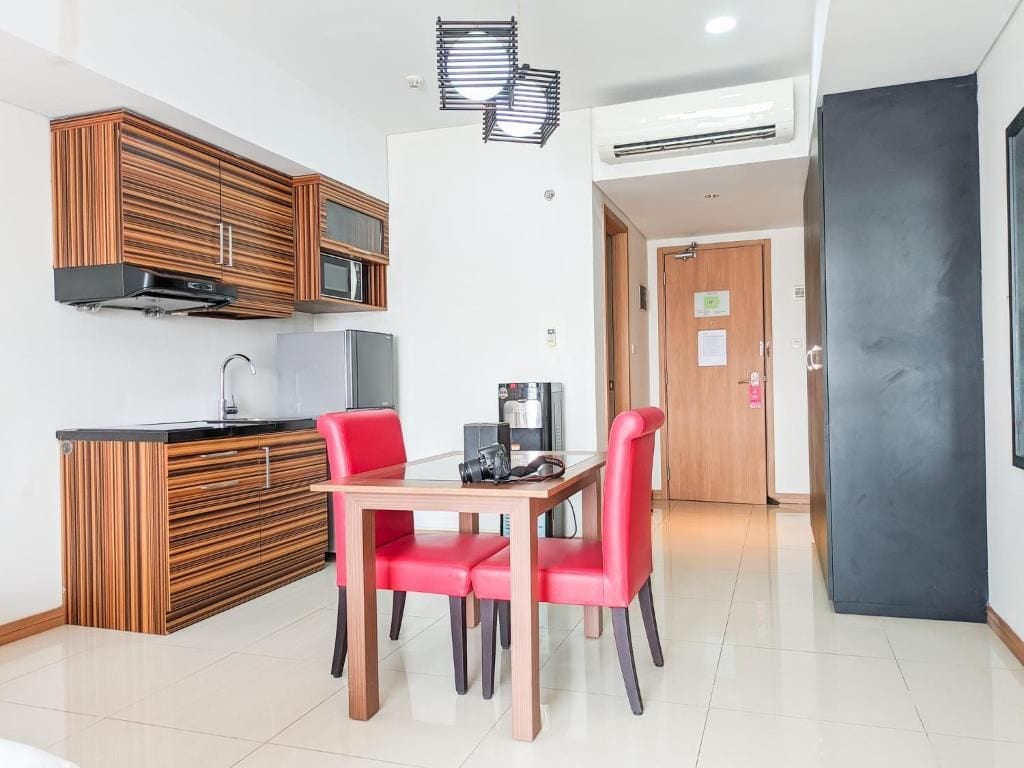 A modern kitchen with a built-in microwave, a coffee machine, and a dining area with a table and two chairs.