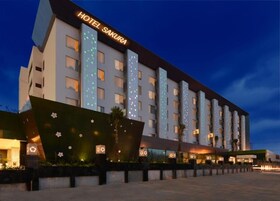 Un hotel de varios pisos con un diseño moderno, que cuenta con una entrada destacada y un letrero que dice 'HOTEL SAKURA'.