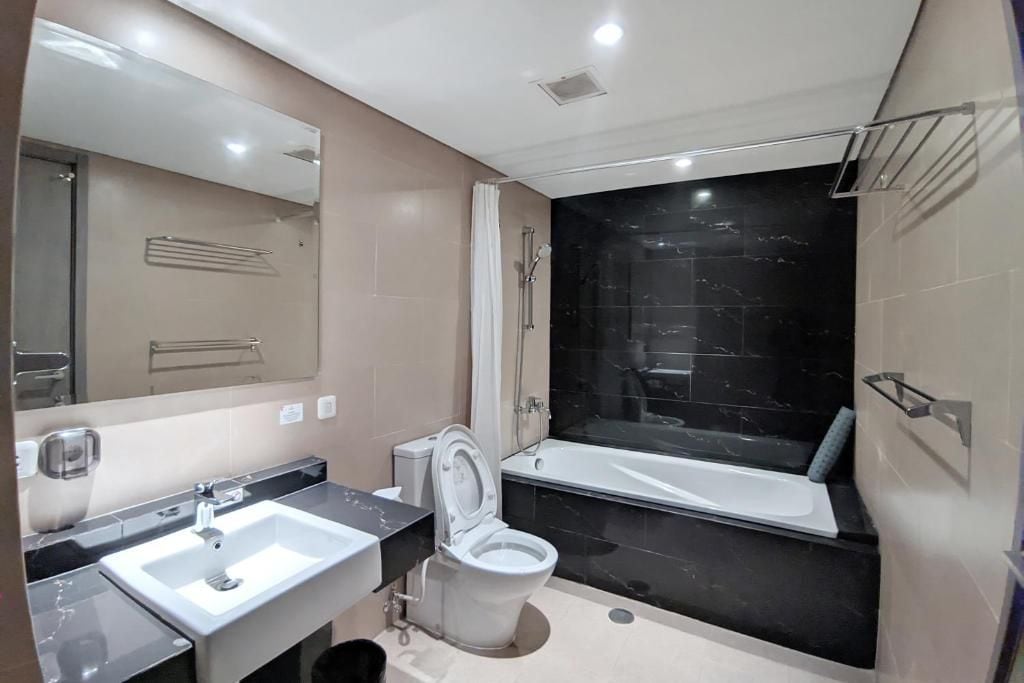 Une salle de bain moderne avec un lavabo, des toilettes et une baignoire.
