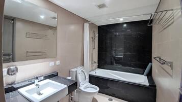 A modern bathroom with a sink, toilet, and bathtub.