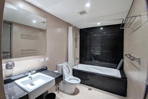 A modern bathroom with a sink, toilet, and bathtub.