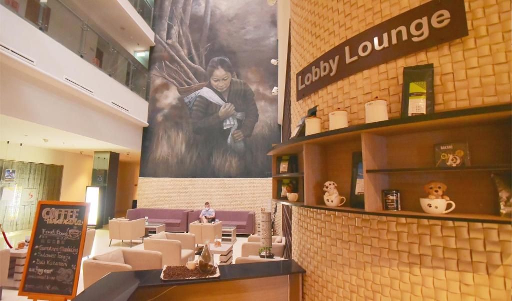 A lobby lounge with a large mural, a coffee bar, and seating areas.