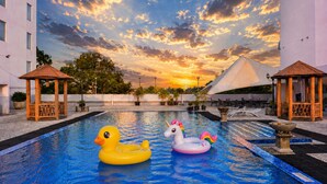 Une piscine avec deux jouets gonflables, un gazebo et une tente en arrière-plan.
