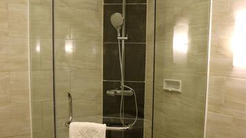 A modern bathroom with a glass-enclosed shower, a white bathtub, and a black vanity.