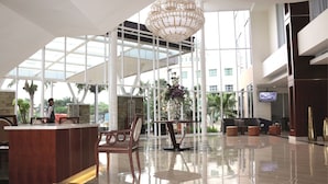 A spacious lobby with a reception desk, seating area, and a large chandelier. - Java Palace Hotel (Cikarang)