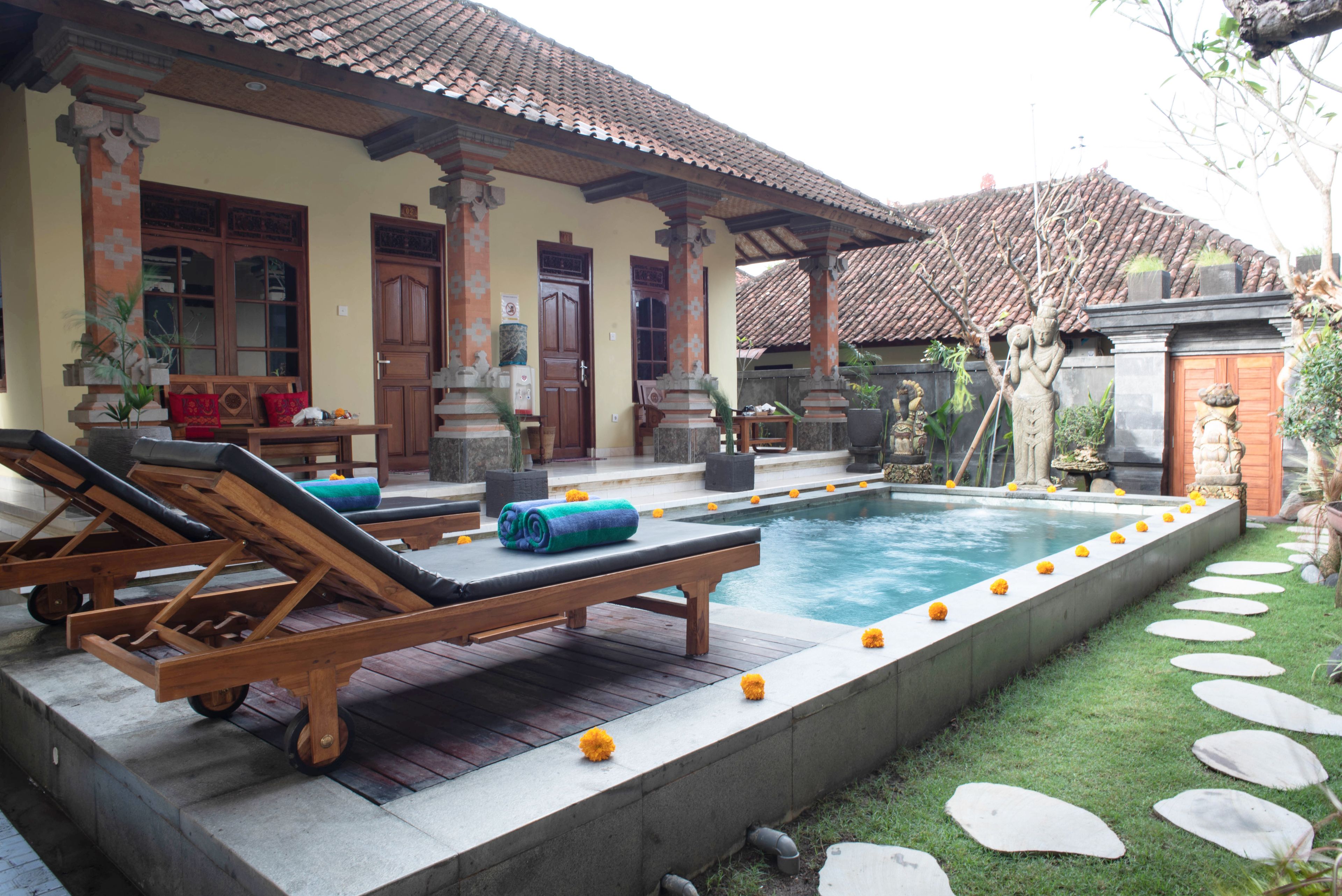 A poolside area with lounge chairs, a small pool, and a garden with stepping stones.