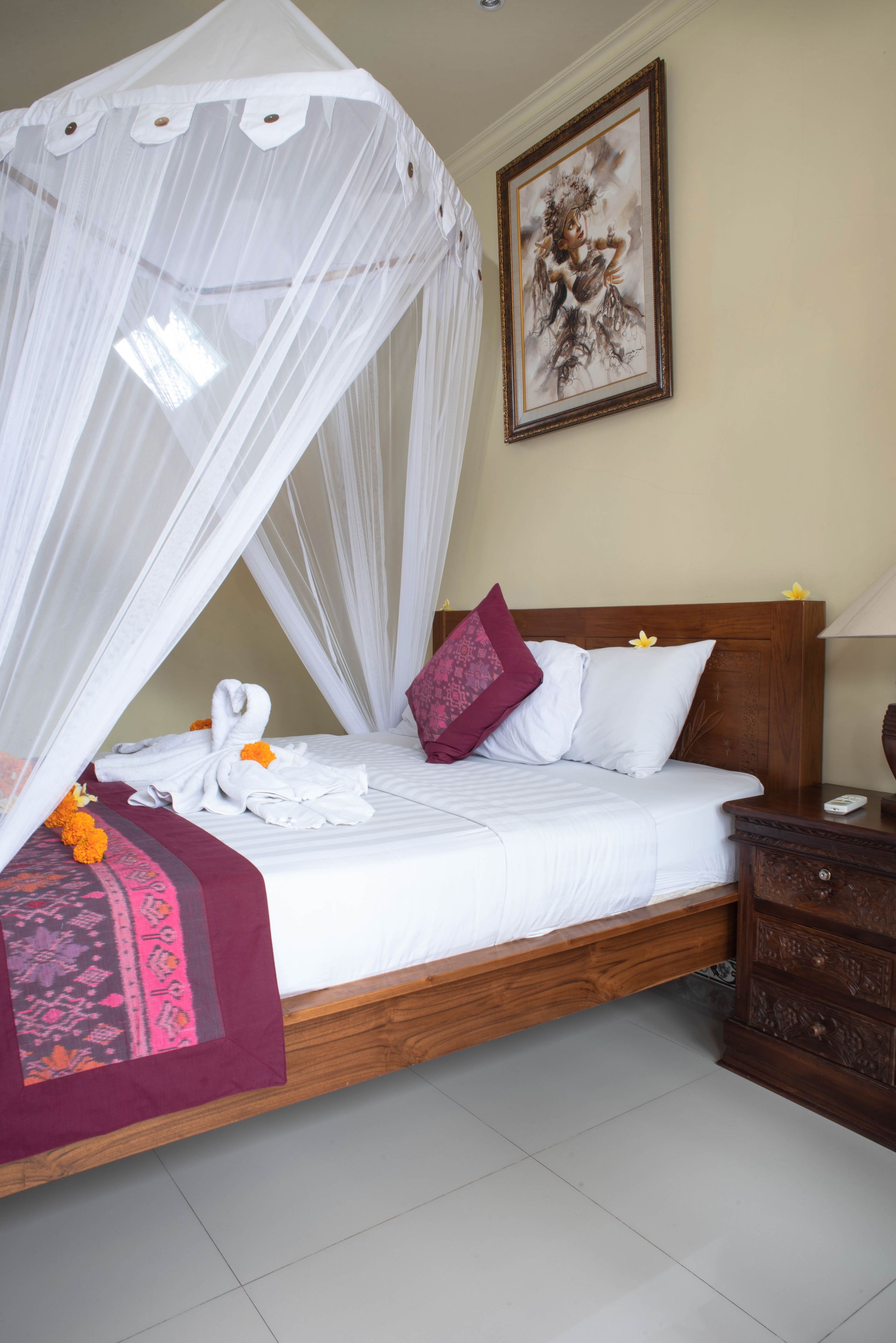 A neatly made bed with a canopy, a wooden headboard, and a bedside table with a lamp.