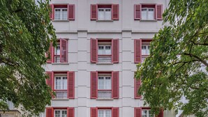 A hotel facade with a symmetrical design, multiple windows with shutters, and a prominent entrance with a marquee. - Hotel L Odeon Phu My Hung (Ho Chi Minh City)