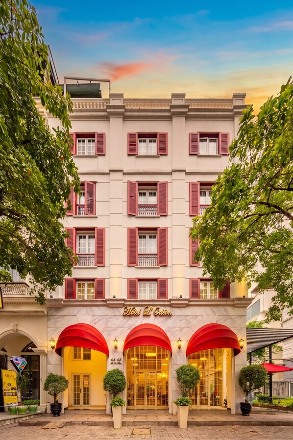 A hotel with a classic facade, multiple windows with shutters, and a prominent entrance with a marquee sign. - Hotel L Odeon Phu My Hung (Ho Chi Minh City)