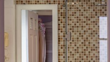 A bathroom with a white sink, a mirror, and a shower area.