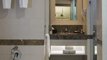 Un baño moderno con bañera, tocador con espejo y zona de ducha.