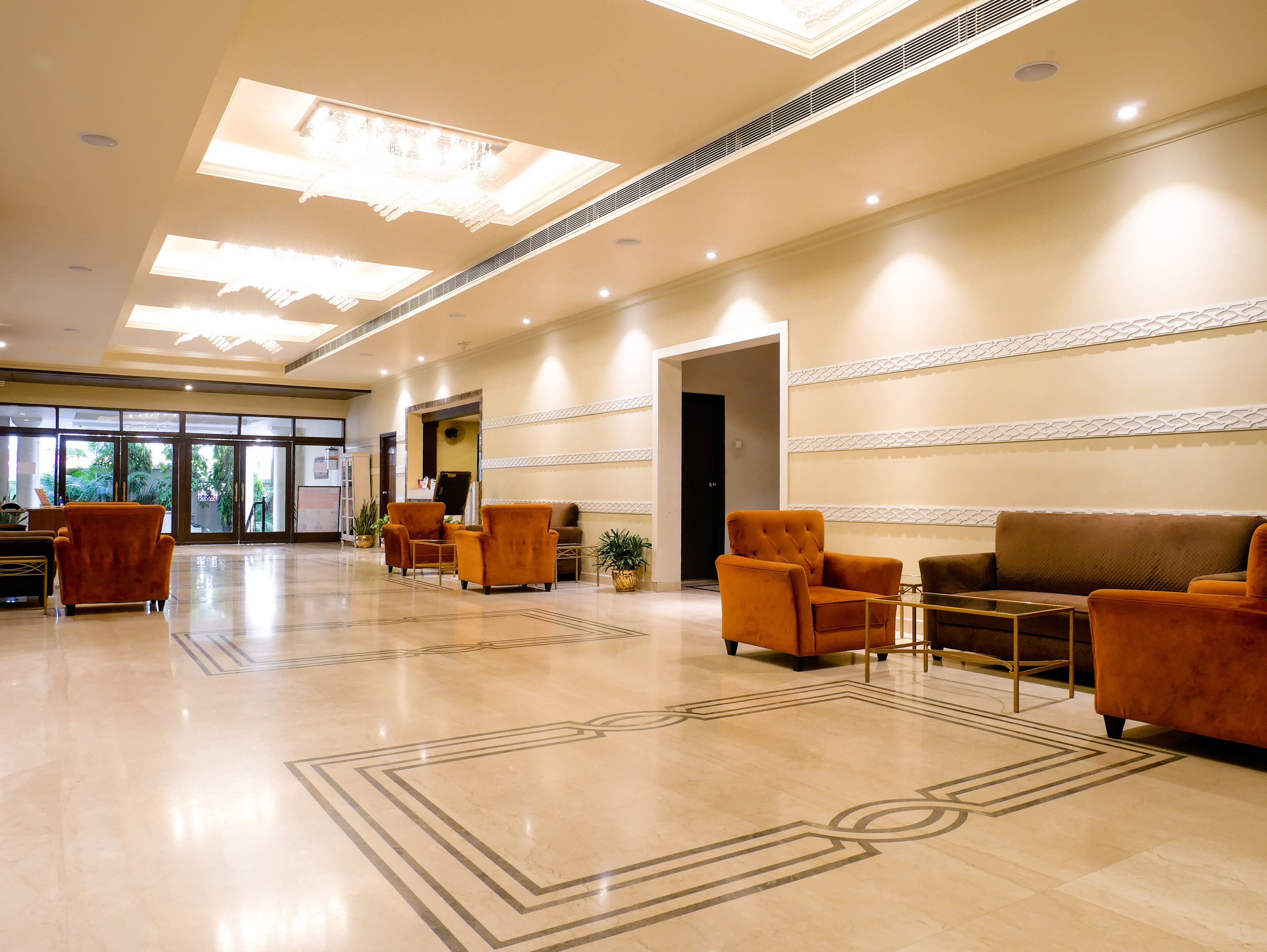 A spacious lobby with a polished marble floor, a reception desk, and seating areas.