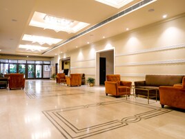 A spacious lobby with a polished marble floor, a reception desk, and seating areas.