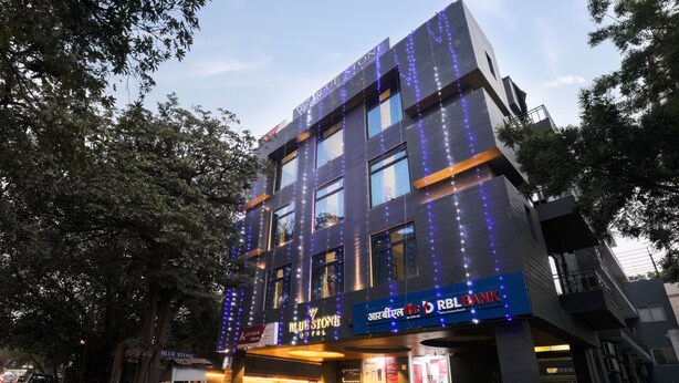 A modern building with a sign for 'Blue Stone Hotel' and 'RBL Bank' on the facade. - Hotel BlueStone - Nehru Place (New Delhi)