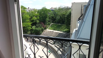 Un balcón con vistas a un parque y un edificio.