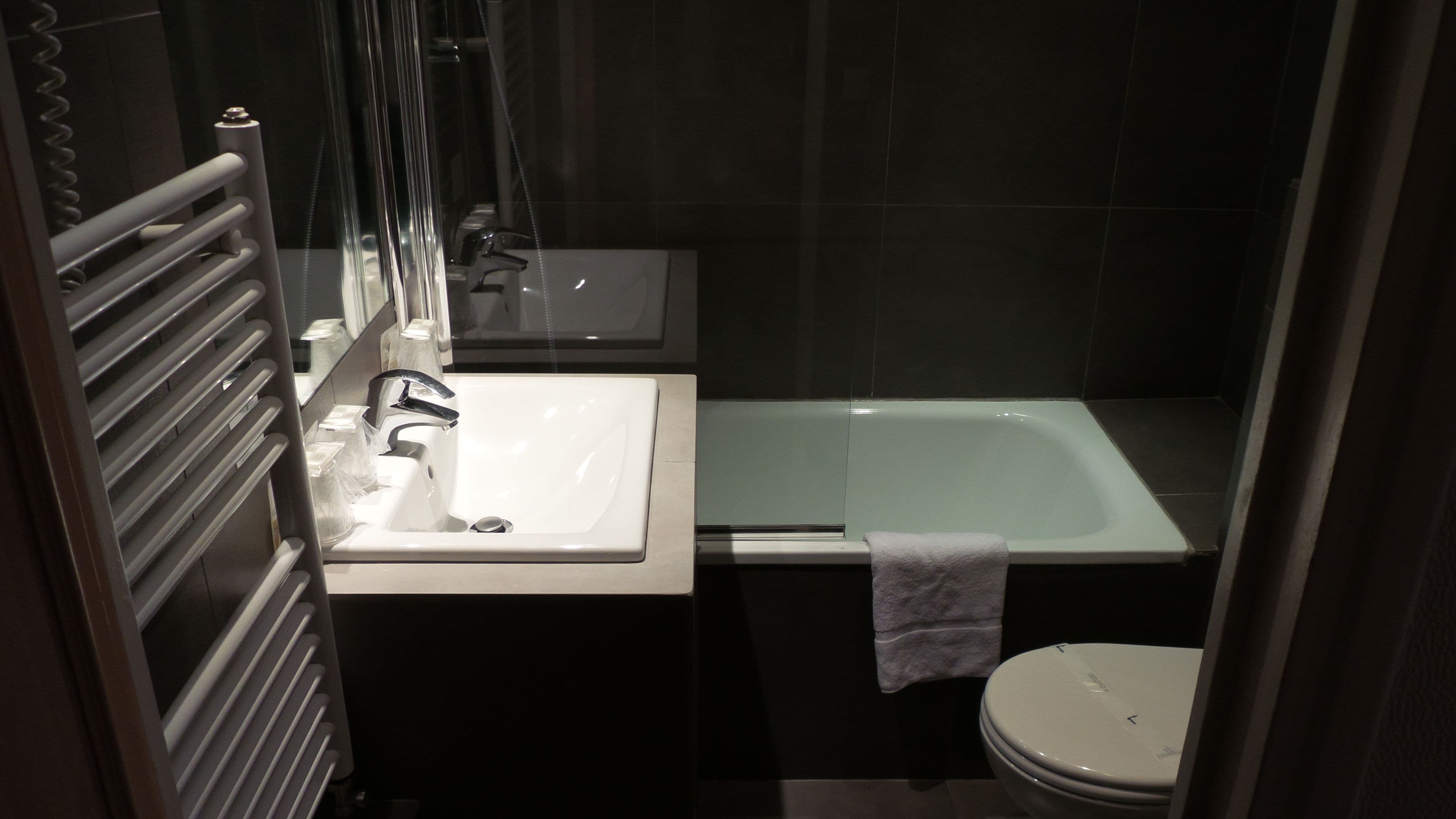 A bathroom with a white sink, a bathtub, and a toilet.