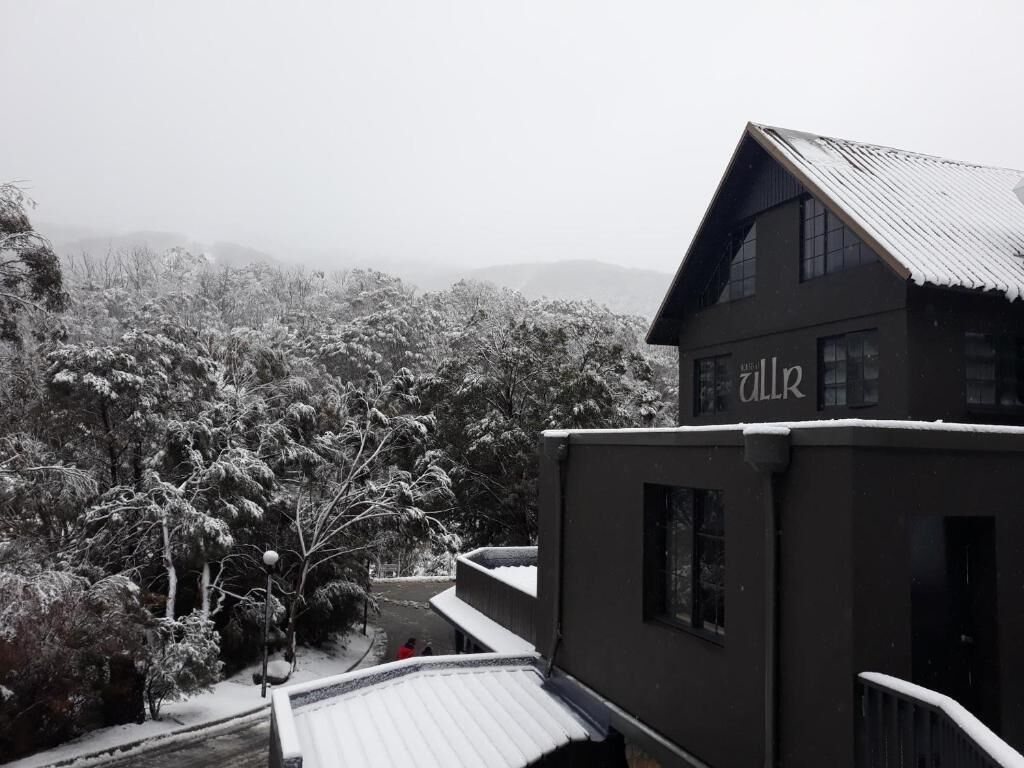 A building with a sign reading "Alk" amidst a snowy landscape.