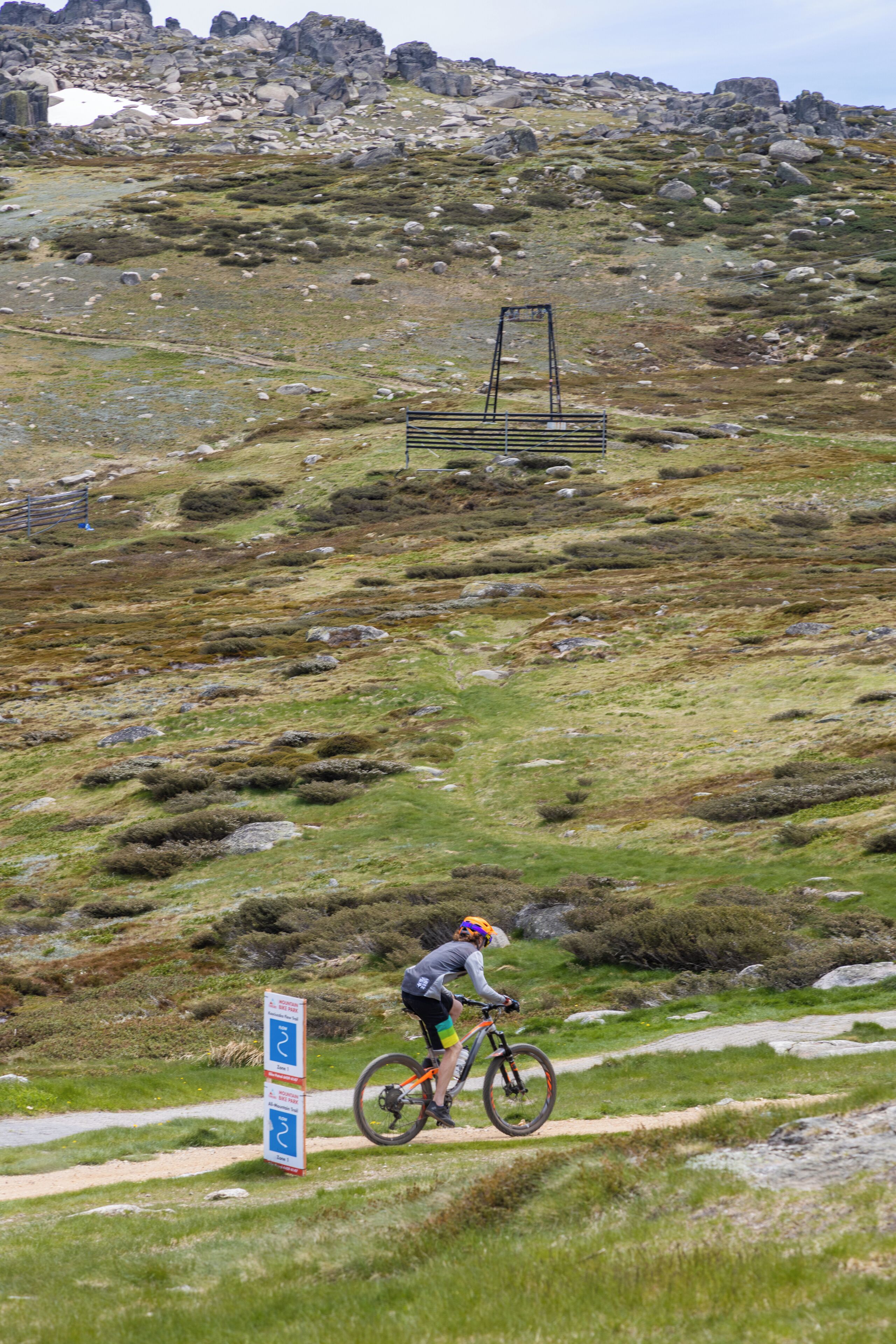 A hilly landscape with a cyclist on a trail.