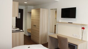A modern hotel room with a bed, a desk, a TV, and a wardrobe. - Prime 20 Serviced Apartments (Frankfurt)