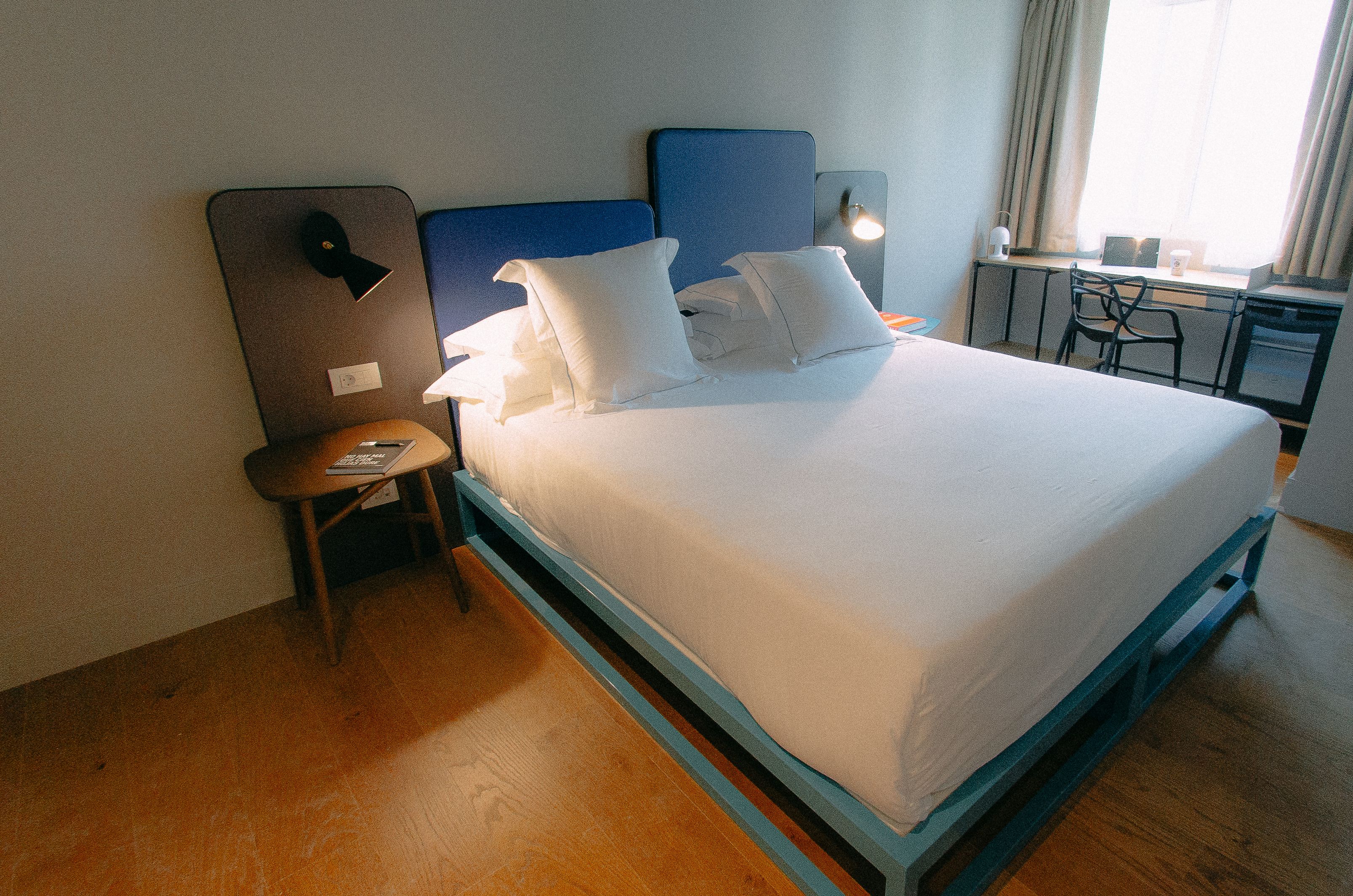 Una habitación de hotel con una cama, un escritorio y una silla.