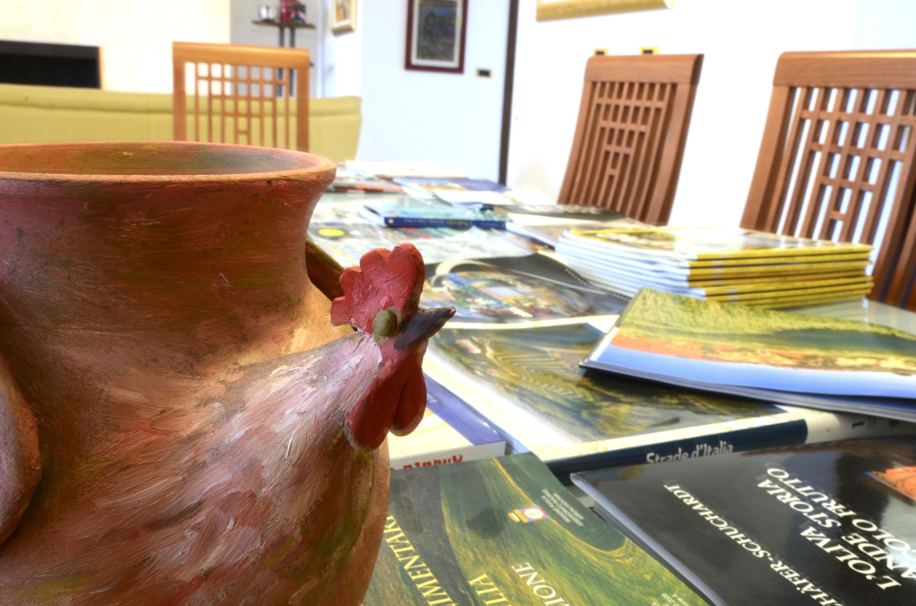 A table with books and a ceramic rooster.