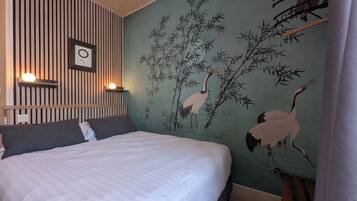 A bedroom with a bed, a wall with vertical wooden slats, and a mural of cranes.