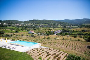 A pool area with a view of vineyards and houses in the background. - Cabeças do Reguengo (Portalegre)