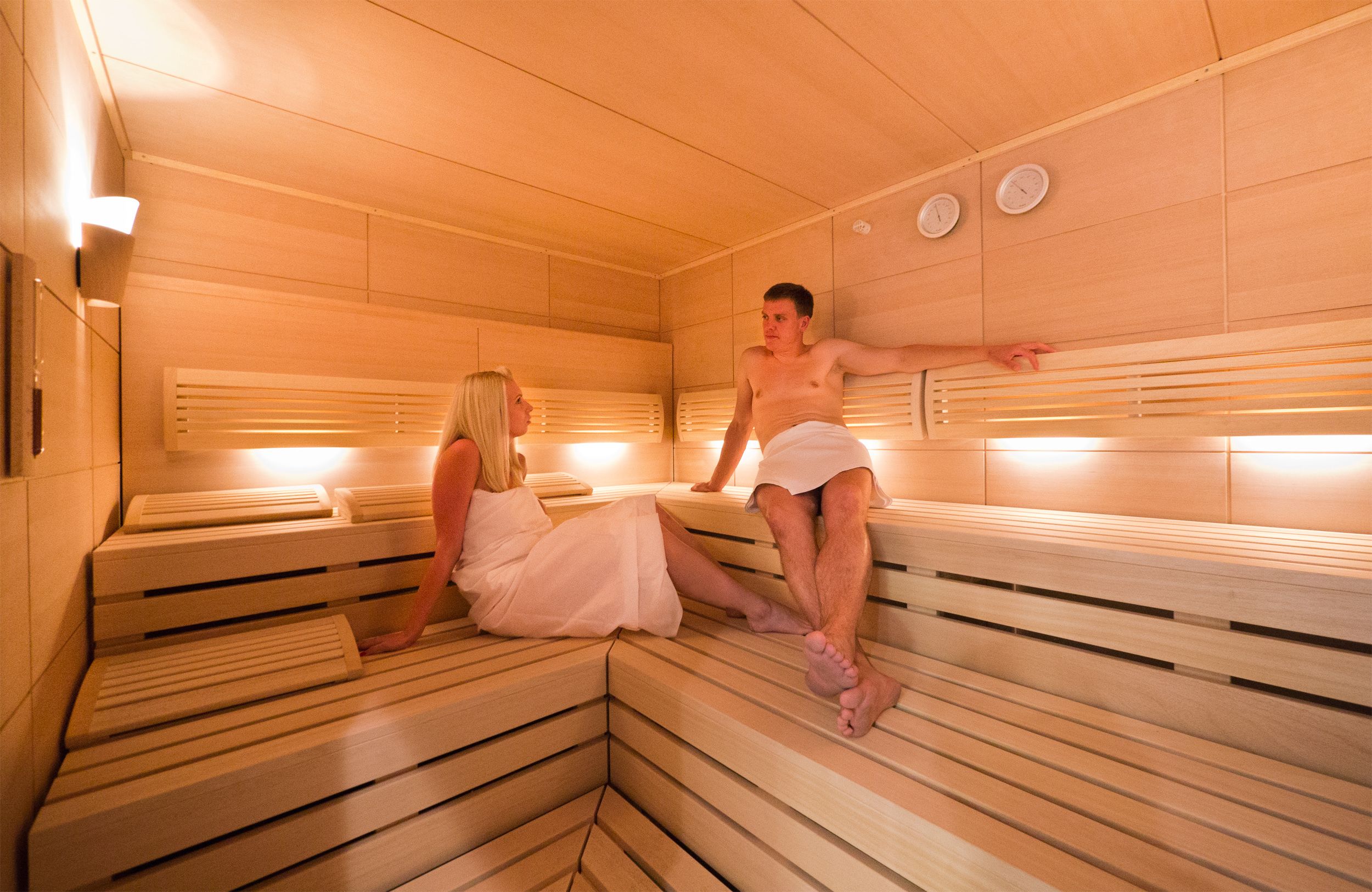 Sauna, jossa on puiset lauteet ja kalteva lattia.