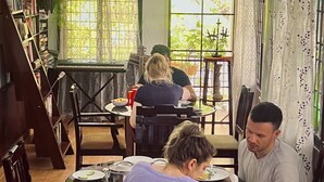 Un comedor acogedor con muebles de madera, un piano y ventanas grandes con cortinas.