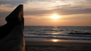 Una puesta de sol sobre el océano con olas acercándose a la orilla.