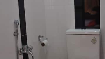 Un baño pequeño con inodoro, ducha y toallero.