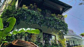 Un edificio de dos plantas con un letrero que dice 'Residenzy Home Stay'.