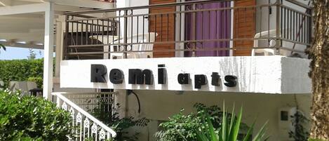 A building with a balcony and a sign that reads "Remi apts".