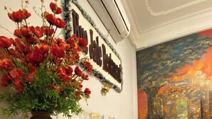 Una mesa de buffet con distintos alimentos y un jarrón decorativo con flores rojas.