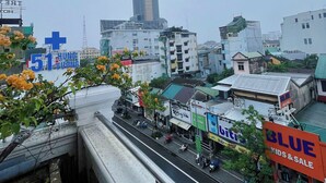 Un paisaje urbano con un rascacielos destacado, una calle concurrida y varios edificios comerciales.