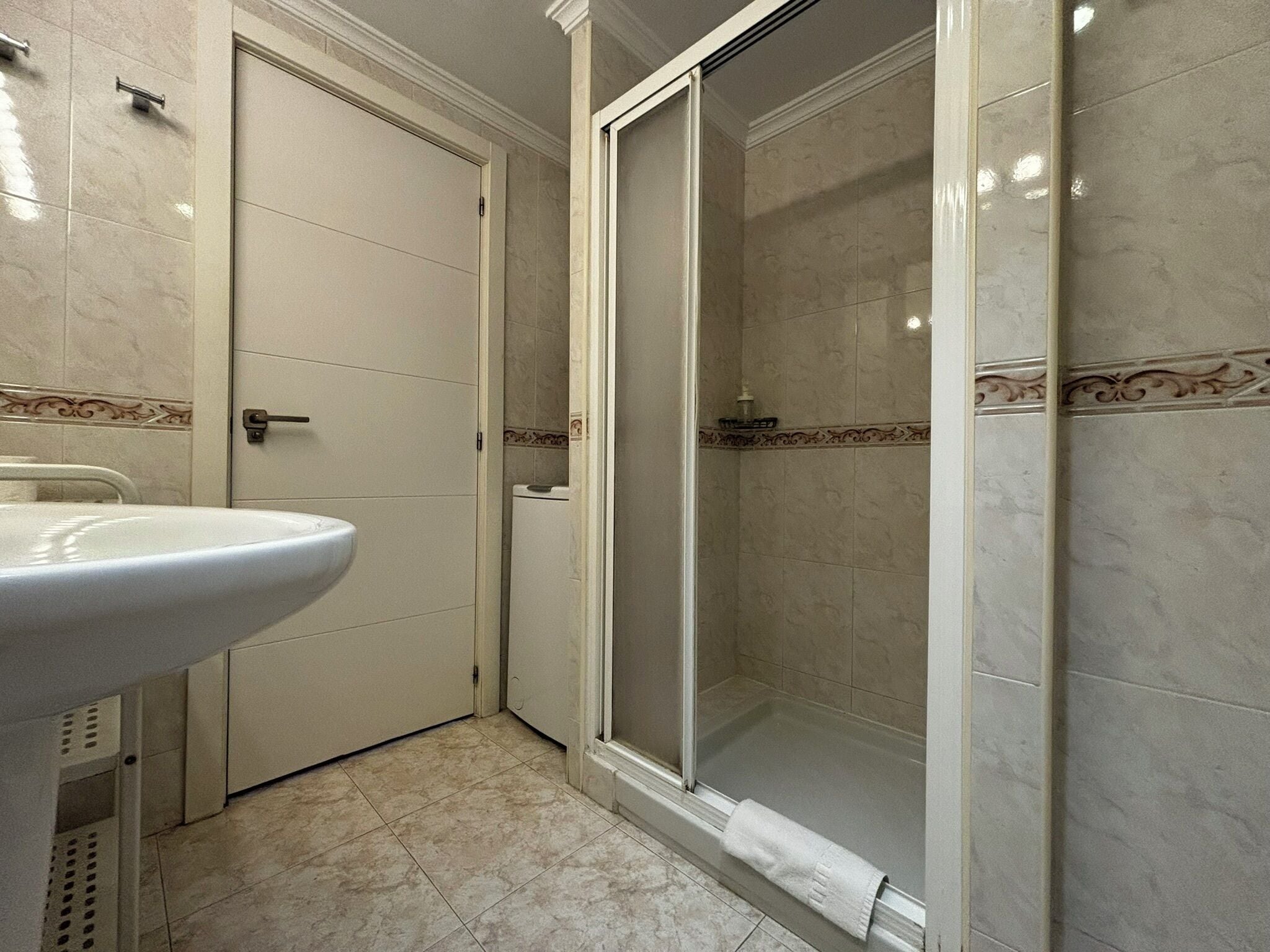 Een badkamer met een wastafel, toilet en douchecabine.