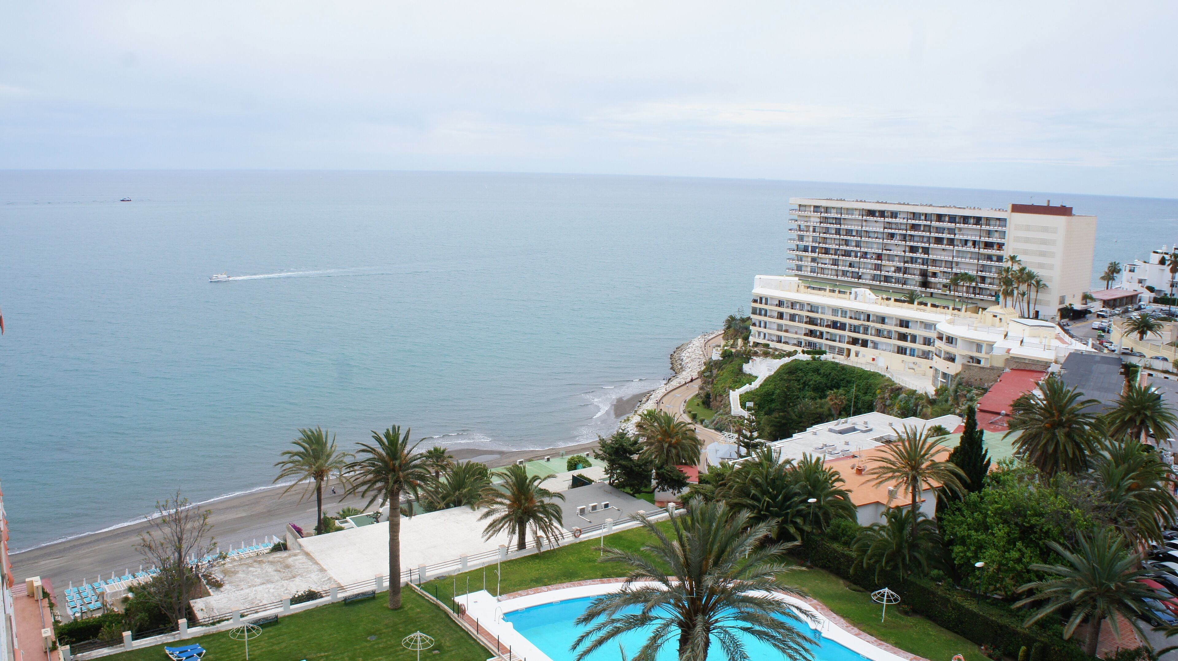Un hotel con piscina, acceso a la playa y vistas al océano.
