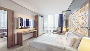 Une chambre d’hôtel moderne, dotée d’un grand lit, d’un bureau, d’une chaise, d’une petite table et d’un panneau décoratif mural.