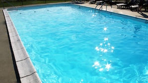 A rectangular swimming pool with clear blue water and a concrete edge. - Cape View Motel (North Truro)