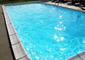 Una piscina al aire libre de temporada, sombrillas