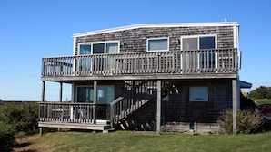 A two-story house with a balcony, large windows, and a wooden deck. - Cape View Motel (North Truro)