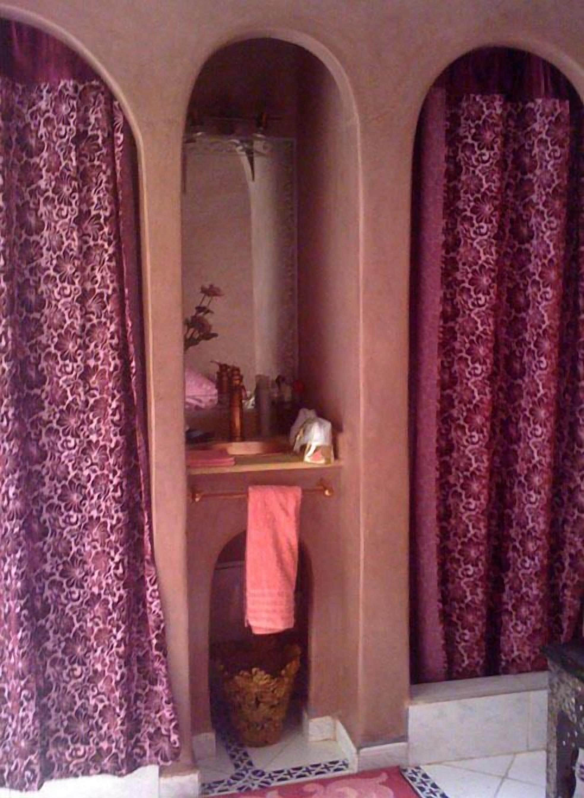 A bathroom with a mirror, a towel rack, and a sink.