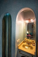 Un bagno con uno specchio grande, un lavandino e un portaservizi.