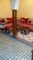 Um conjunto de ferrovias em miniatura com uma área de refeições, incluindo um sofá e um banquinho.