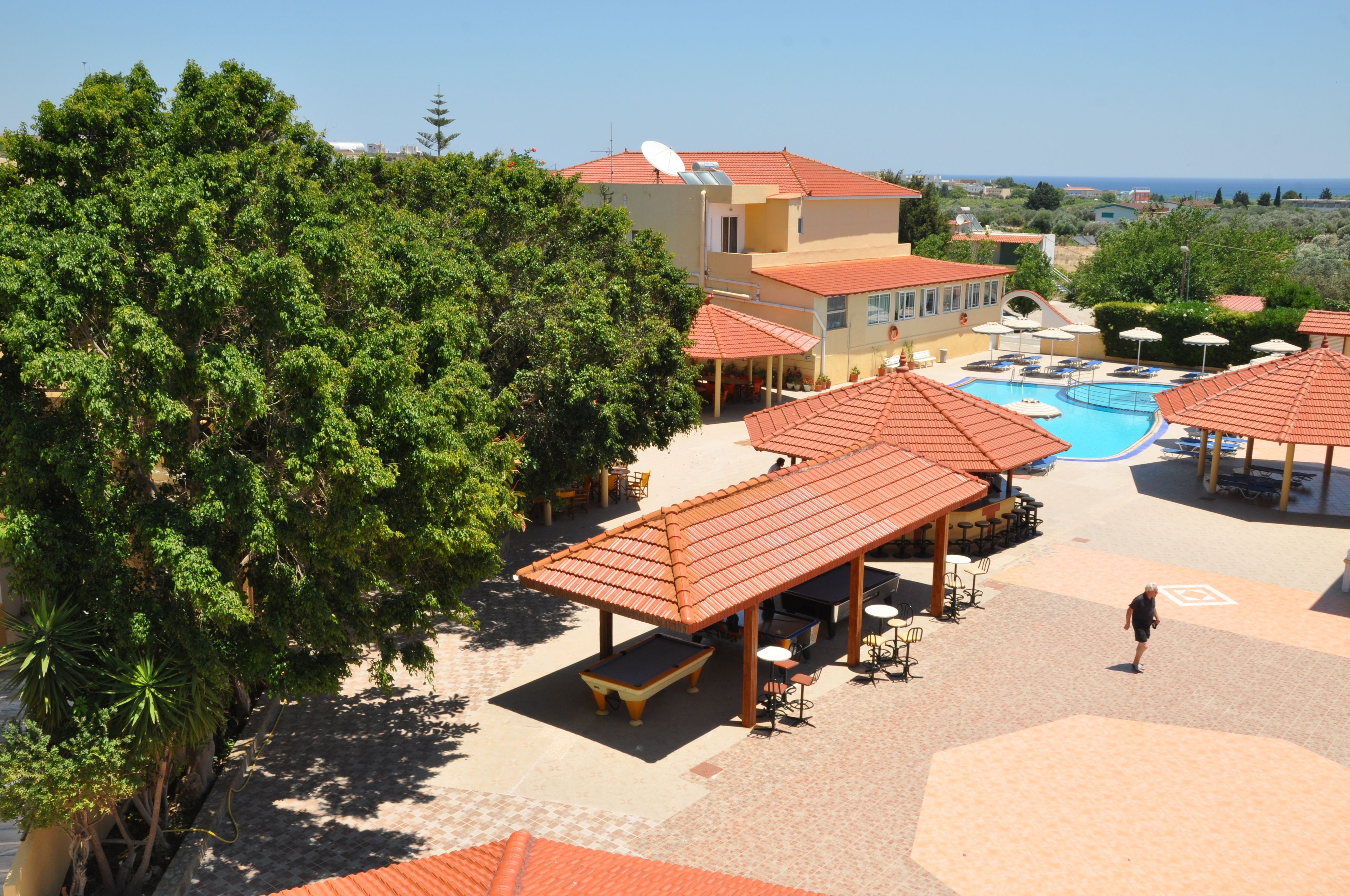 Un resort con piscina, mobiliario exterior y vistas al mar.