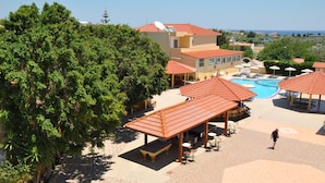 Un resort con piscina, mobiliario exterior y vistas al mar.