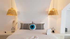 Un dormitorio moderno con una cama grande, dos lámparas colgantes y un diseño de techo único.